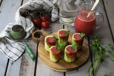 some food is on a wooden plate and next to a glass of water with a straw in it