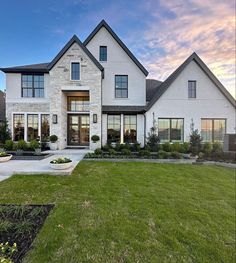 a large white house sitting on top of a lush green field