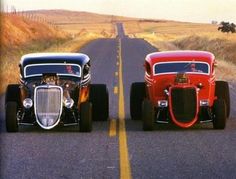 two classic cars driving down the road in front of each other