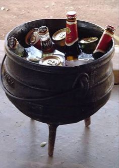 a metal bucket filled with beer bottles on top of a wooden table