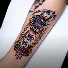 a tattoo with an image of a clock and eye on it's arm,