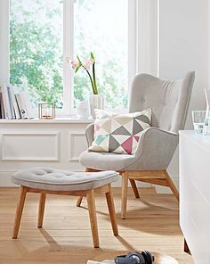 a chair and ottoman in front of a window