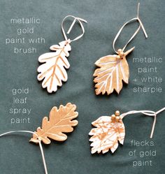 four different types of metal leaf ornaments hanging from strings on a green surface with words describing metallic, gold, and brush