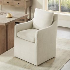 a white chair sitting in front of a table with a cup on top of it