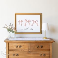 a wooden dresser with a painting on the wall above it