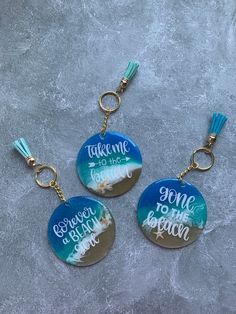 three keychains with the words take me to the beach on them