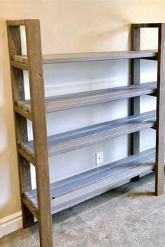 an empty book shelf in the corner of a room with carpeted floor and walls