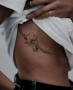 a woman's stomach with a flower tattoo on it