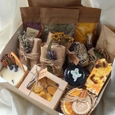 a box filled with lots of different types of food and candles on top of a white blanket