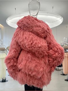 the back of a woman's pink coat in a store