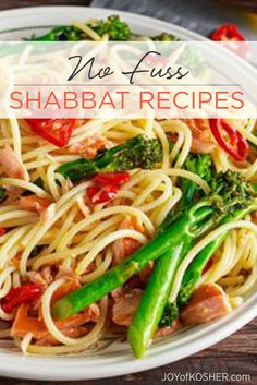 a white plate topped with pasta and veggies on top of a wooden table