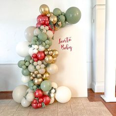 the balloon arch is made up of balloons and greenery for a baby's first birthday