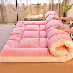 a person laying on top of a pink mattress