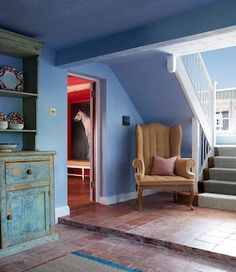 a living room with blue walls and stairs