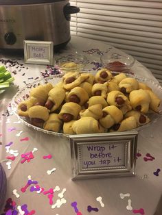 a platter full of pigs in a blanket on a table with confetti