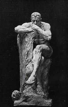 a black and white photo of a man sitting on a rock with his arms crossed