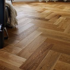 an empty room with wood flooring and a chair next to the wall in front of it