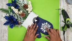 someone is making snowflakes out of felt on a green surface next to scissors and flowers