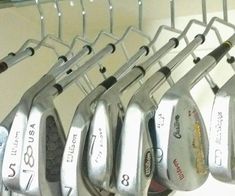 several golf clubs are hanging on a rack