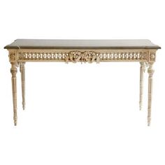 an antique console table with marble top and carved details on the legs, against a white background