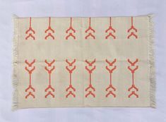 an orange and white rug with arrows drawn on the front, in rows of red crosses