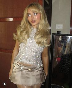 a mannequin wearing a short skirt and sequined top in front of a mirror