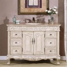 a bathroom vanity with two sinks and a painting on the wall above it in a room