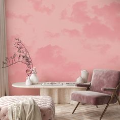 a living room with pink walls and furniture in front of a table that has flowers on it