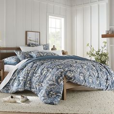 a bed with blue and white comforters in a bedroom