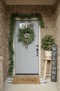 a front door with a welcome mat and wreath