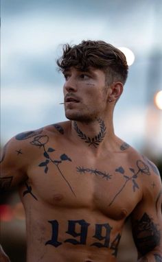 a shirtless man with tattoos on his chest