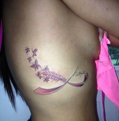 a woman's stomach with a pink ribbon around it and flowers on the side