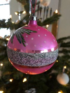 a pink ornament hanging from a christmas tree