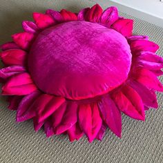 a pink sunflower pillow sitting on the floor