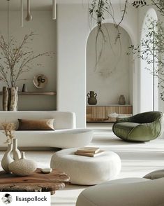 a living room filled with white furniture and plants