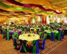 a banquet hall filled with tables covered in colorful cloths