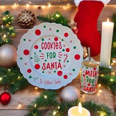 cookies for santa plate next to candles and christmas decorations