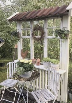 an outdoor area with chairs, table and potted plants