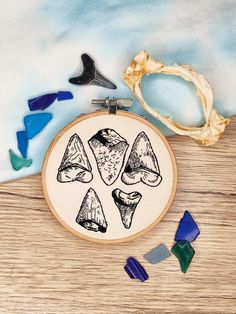 "Make your own colourful hand-embroidered wall art with this in-depth PDF embroidery pattern. This pattern will help you to create my popular \"Shark Week\" vintage inspired sharks tooth design. This is an beginner/intermediate ability level pattern. I would recommend you have some experience using split stitch and/or backstitch with this pattern. You can use whatever colours and stitches you like, to create your own individual piece of art, however I do provide suggestions of colours through visual photographic and digitally drawn aids, together with the stitches I have used so you can match the picture. This design was originally designed for a 4 inch hoop. This has a pre-sized 4-inch and 6-inch template included, as well as the original design in a resizable bitmap file so you can adjus