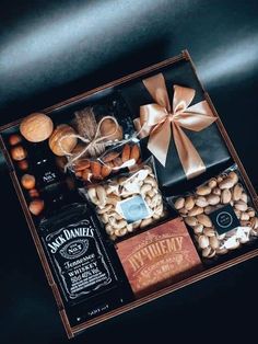 an assortment of nuts and liquor in a wooden box with a bow on the top