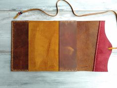 four different colors of leather on a white wooden table with a brown cord attached to it