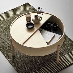 a coffee table with an open section on the top and two cups sitting on it