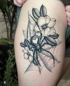 a woman's thigh with flowers and leaves tattoo on the side of her leg