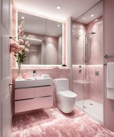 a bathroom with pink walls and flooring has a large mirror above the sink, along with a white toilet