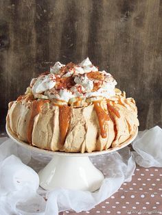 a cake sitting on top of a white plate covered in frosting and toppings