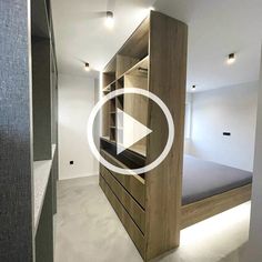 a bed sitting in the middle of a room next to a wooden shelf with drawers