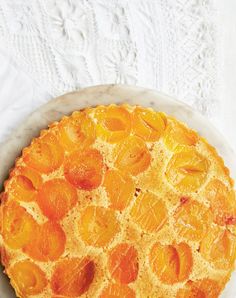 an orange pie on a plate with white table cloth