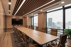 an empty conference room with large wooden tables and chairs in front of huge windows overlooking the city