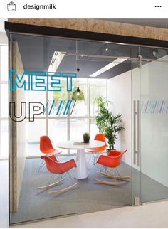 an office meeting room with glass walls and chairs