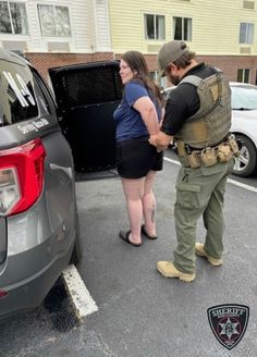 two people standing in front of a car with the back door open